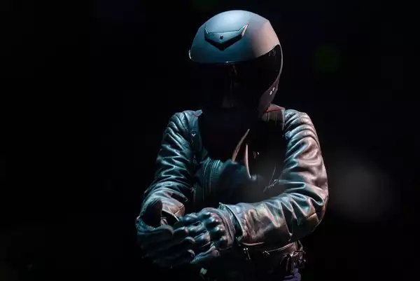 A person wearing a helmet and leather biking gear