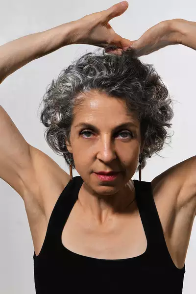 Headshot of Betsy Cooper wearing a black vest top on a white background