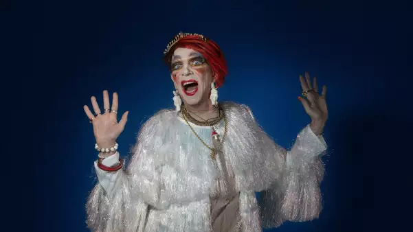 David Hoyle wearing a sparkly top on a black background