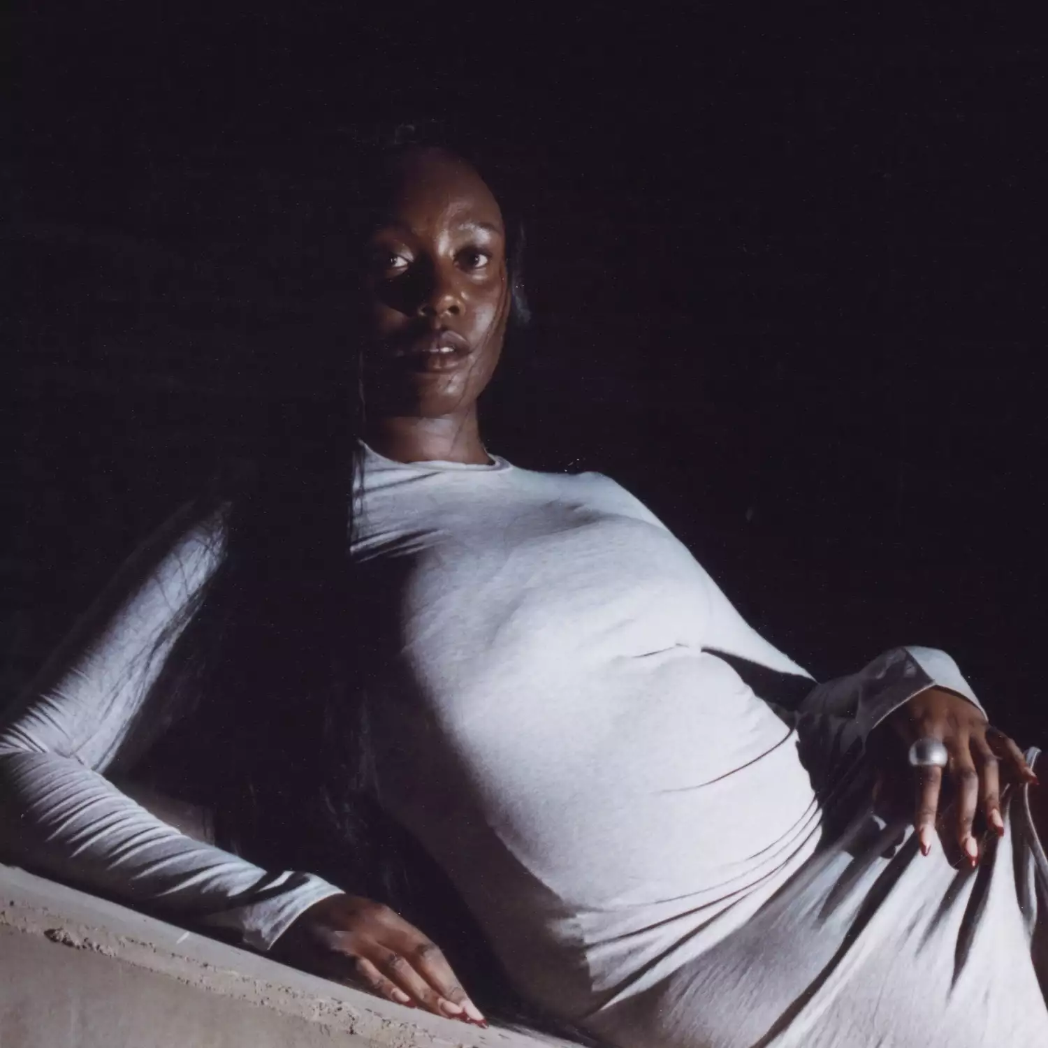 Headshot of Lenacha Lema wearing white on a black background