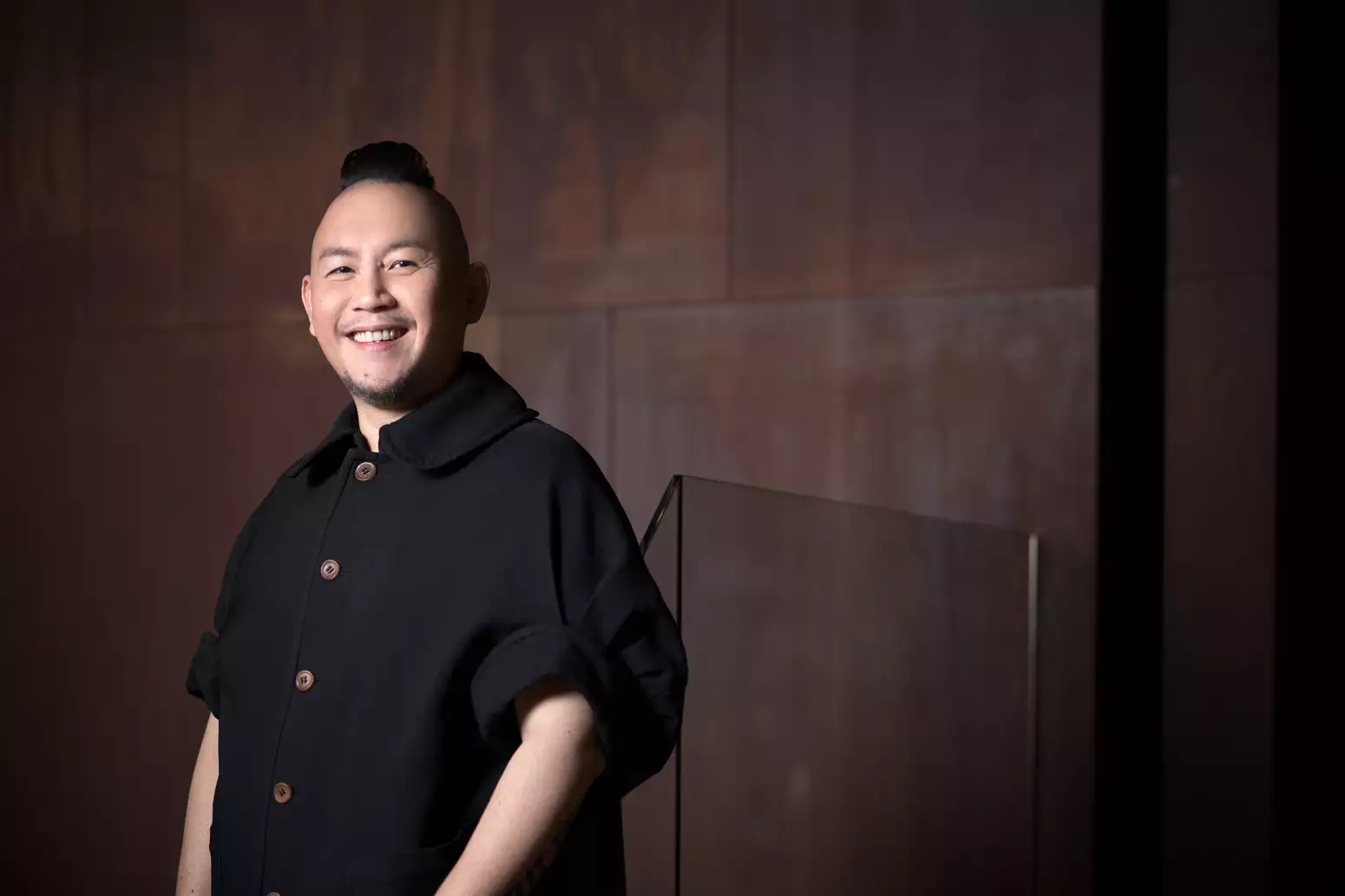 Smiling man in black shirt with short billowing sleeves