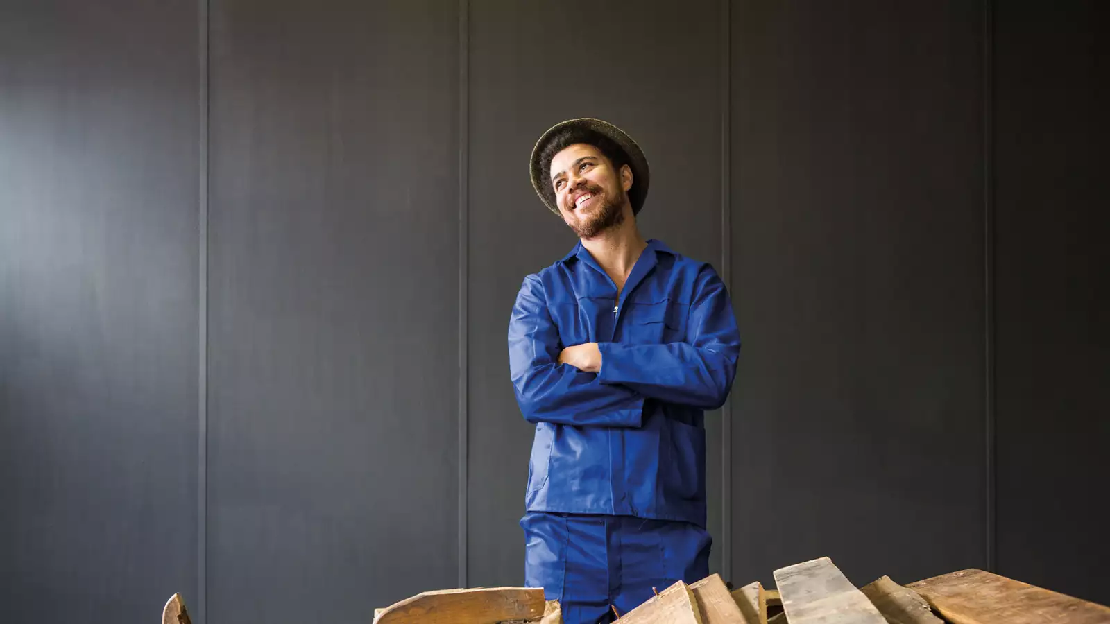 Photographic portrait of Kemang wa Lehulere stood behind planks of wood
